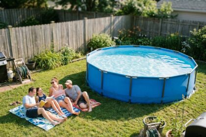 Piscine autoportée ronde installée dans un jardin de maison individuelle en été avec de l'eau bleue cristalline